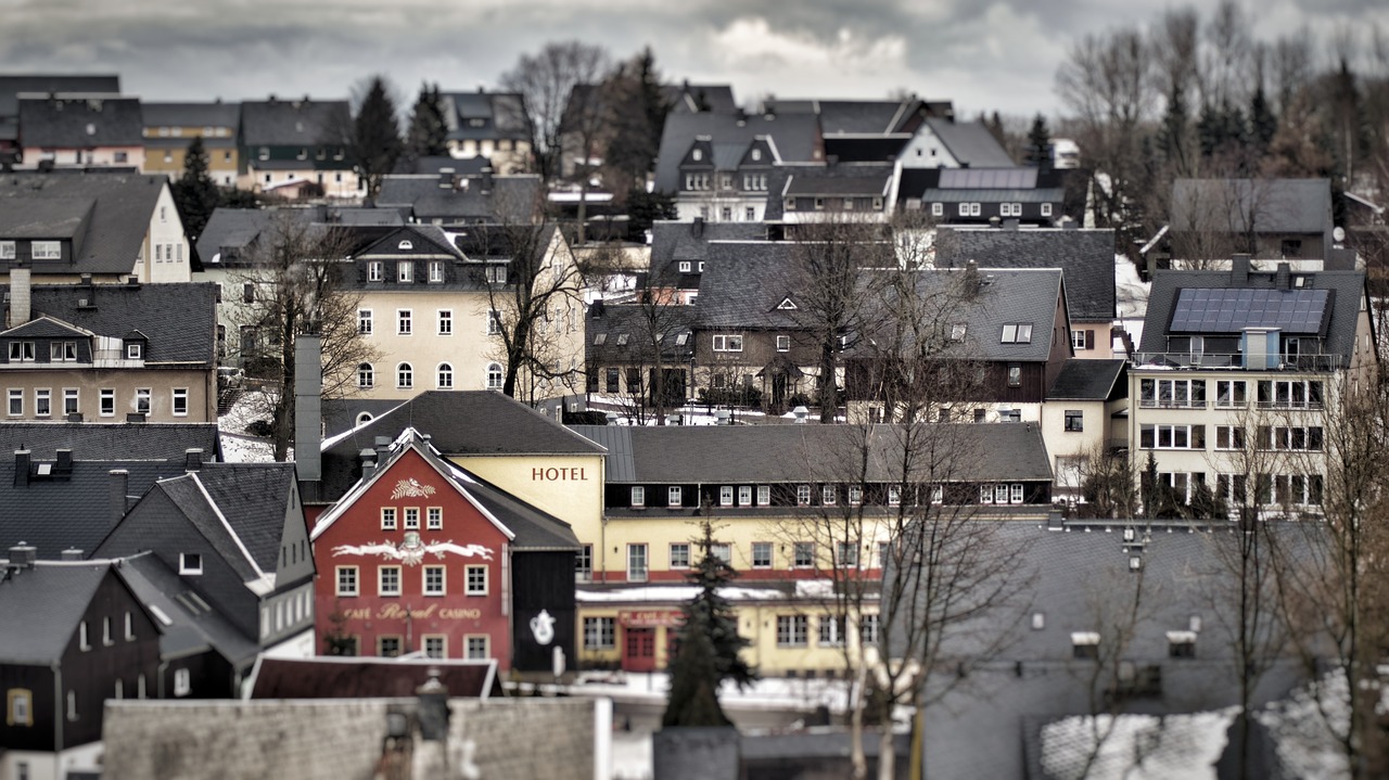 a bunch of beige, white and black houses with one red house near the center