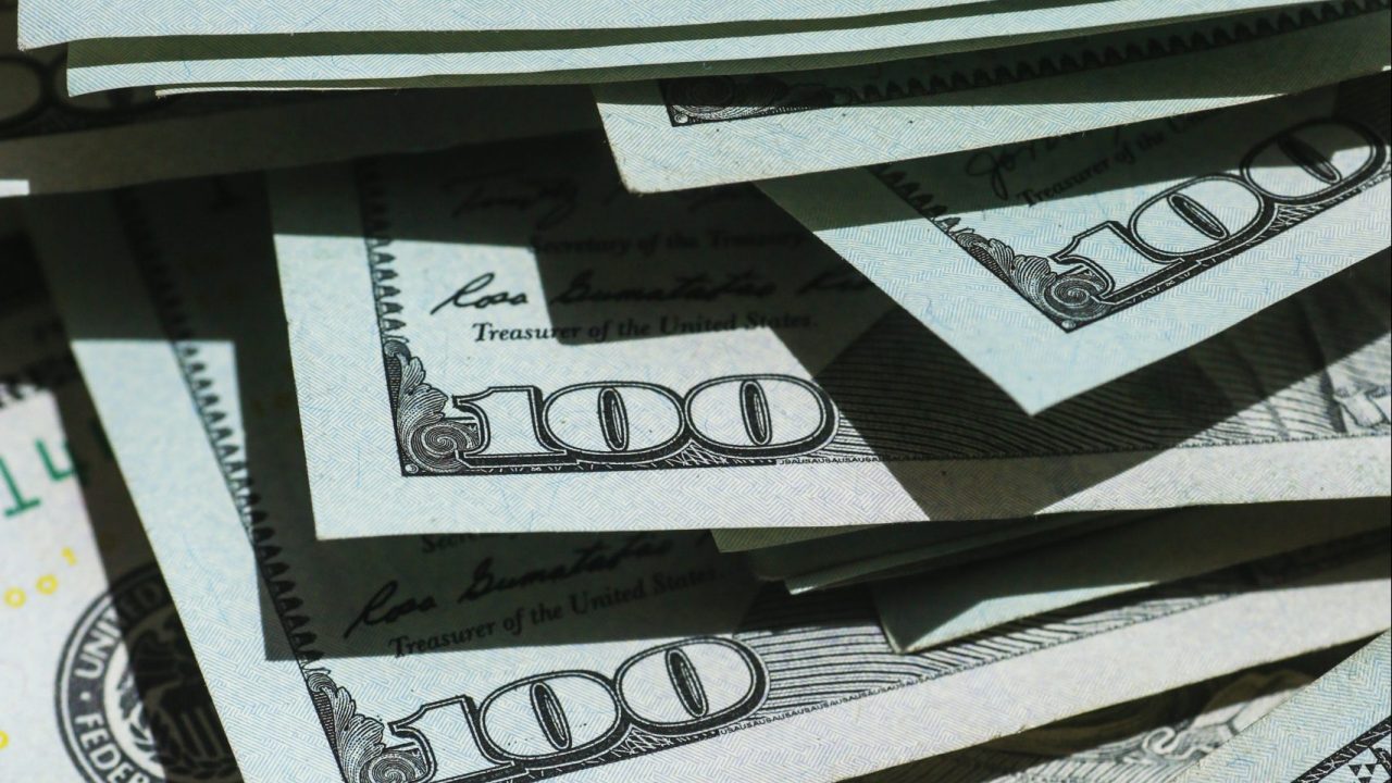 100 dollar bills in a pile