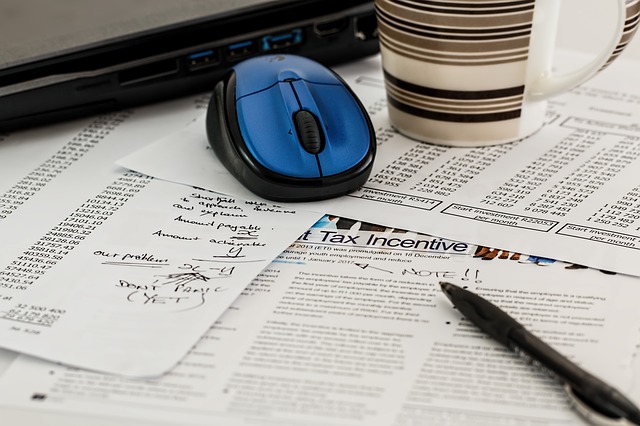 computer mouse atop tax forms on a desk