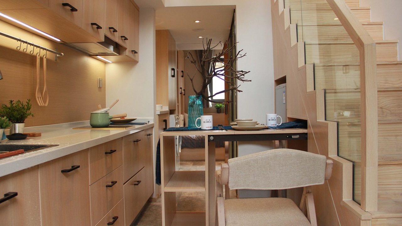hallway with a pullout kitchenette nearby a stairway and kitchen counter