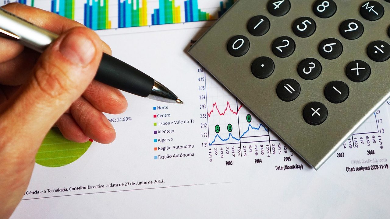 close up on hand marking charts and calculators