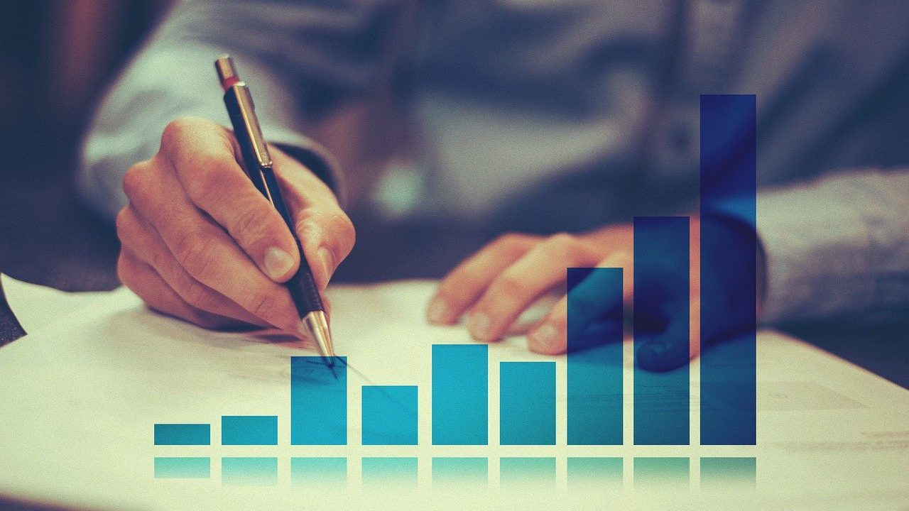 hands on desk, writing paper with a superimposed chart in the foreground