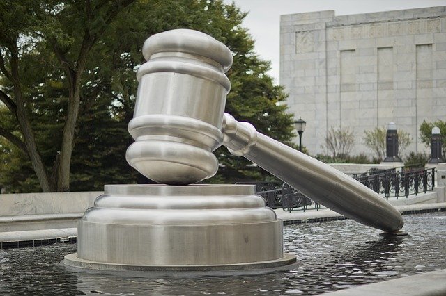 a stone statue of a gavel in a fountain